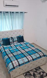 a bed in a bedroom with a blue curtain at Chez Bryan in Avéméné