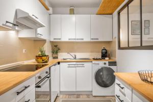 a kitchen with white cabinets and a dishwasher at LE MARNI appartement central avec terrasse parking privé in Menton