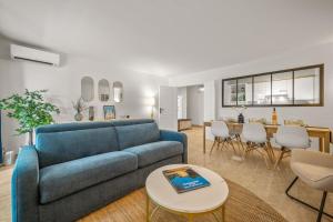 a living room with a blue couch and a table at LE MARNI appartement central avec terrasse parking privé in Menton +43 photos