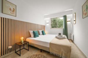 a bedroom with a large bed with a window at LE MARNI appartement central avec terrasse parking privé in Menton