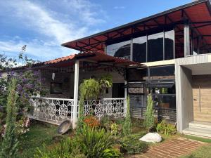 a house with a white fence in the yard at Finca San Barbara in Pavas
