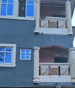 a blue building with white columns and windows at Chez Bryan in Avéméné