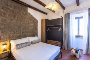 a bedroom with a bed and a brick wall at Marta Lake Albergo Diffuso & Spa in Marta