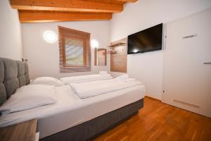 a bedroom with a large bed and a flat screen tv at Ski Chalet Jim by All in One Apartments in Zell am See
