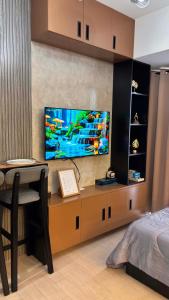 a bedroom with a tv and a desk with a chair at Ciao Vacanza Staycation in San Fernando