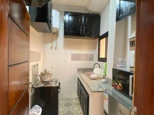 a small kitchen with a stove and a refrigerator at Lita Residence in Yaoundé