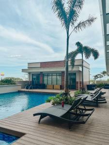 a group of lounge chairs next to a swimming pool at Ciao Vacanza Staycation in San Fernando