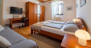 a bedroom with a bed and a desk and a tv at Danilo Room in Pula