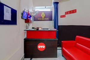 a room with a red chair and a counter at Hotel O Shiva Grand in Chinhat