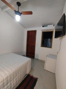 a bedroom with a bed and a ceiling fan at Casinha Centro histórico in Paraty