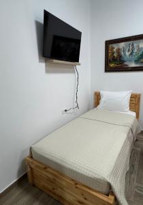a bedroom with a bed with a flat screen tv on the wall at The White Villa - Guest House in Bogovë +22 photos