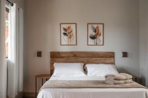a bedroom with a bed with two pictures on the wall at Sattva Pousada in Pirenópolis