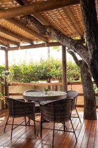 a patio with a table and chairs under a tree at Sattva Pousada in Pirenópolis