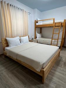 a bedroom with two bunk beds and a ladder at The White Villa - Guest House in Bogovë