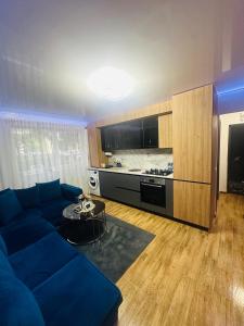 a living room with a blue couch and a kitchen at A&B Apartaments2 in Târgu Ocna