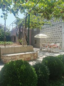 a patio with a table and an umbrella at Apartman Alba in Petrovac na Moru