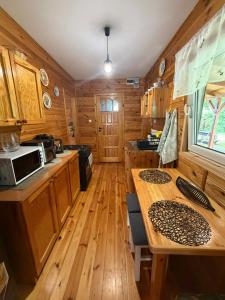a kitchen with wooden cabinets and a wooden table at Letniskowy Domek Paullo in Słajszewo