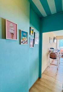 a room with a blue wall with pictures on it at Ticino Lakeview Apartment in Bissone