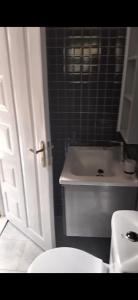 a bathroom with a white toilet and a sink at MPD Deluxe Suites in Kakamega