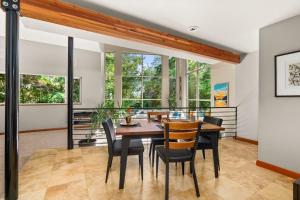 a dining room with a table and chairs and windows at Dash Point Modern in Tacoma