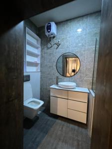 a bathroom with a toilet and a sink and a mirror at Bgold home Apartment in Lekki