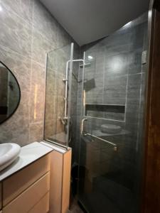 a bathroom with a shower with a glass door at Bgold home Apartment in Lekki