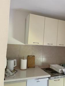 a kitchen with white cabinets and a counter top at Apartman Teodora in Risan