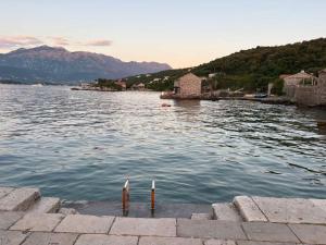 a large body of water with mountains in the background at BlueWave Apartments in Tivat