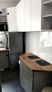 a kitchen with white cabinets and a wooden counter top at Blackapartment2Kawalerka in Olsztyn