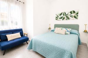 a bedroom with a bed and a blue chair at Center Room Tortolì wifi, AC, free parking, city center at 100 m in Tortolì