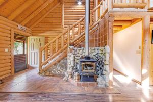 a fireplace in a log cabin with a staircase at Deer Lane Lodge in Idyllwild +16 photos