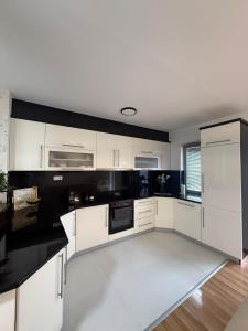 a white kitchen with black and white appliances at DrimResidence in Struga