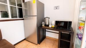 a kitchen with a refrigerator and a table with a microwave at Hotel King del Centro San Miguel in San Miguel