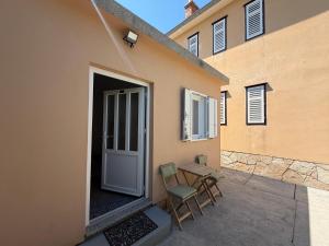 a patio with a table and chairs next to a building at Studio Apartman ISRA 1 in Palit +25 photos