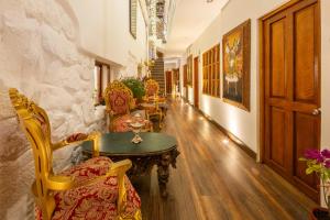 a hallway with chairs and a table in a building at Hotel Monasterio del Inka Cusco in Cusco