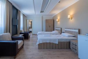 a hotel room with two beds and a couch at Karacan Hotel - Dalaman Airport in Dalaman