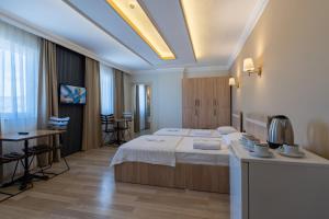 a hotel room with a large bed and a table at Karacan Hotel - Dalaman Airport in Dalaman