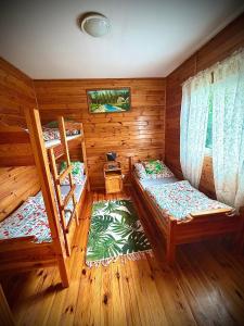 a room with two bunk beds in a cabin at Letniskowy Domek Paullo in Słajszewo
