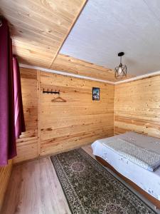 a log cabin with a bed in a room at Tamchy Residents in Tamchy +5 photos