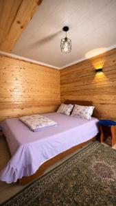 a bedroom with a bed in a wooden cabin at Tamchy Residents in Tamchy
