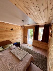 a bedroom with a large bed in a wooden room at Tamchy Residents in Tamchy