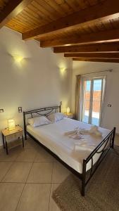 a large bed in a room with a window at Théa Loft Premium Sunset Sea View Escape in Vathý