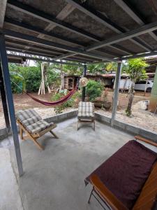 a patio with a hammock and two chairs on it at Pacific villa lisn in Nicoya +15 photos