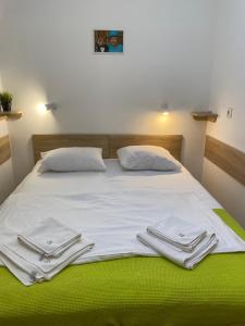 a bed with white sheets and towels on it at Svit home Hamster 007- apart-hotel in Lviv