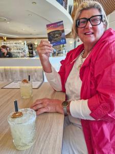 a woman sitting at a table with a drink at Vibrant & Vintage B & B in Greenmount