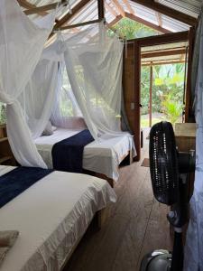 a bedroom with two beds with mosquito nets at Pal Mar in Nuquí
