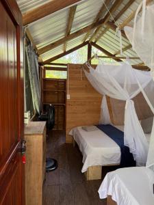 a bedroom with two beds and a mosquito net at Pal Mar in Nuquí