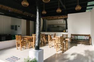 a dining room with wooden tables and chairs at Villa Gumamela Siargao in Catangnan