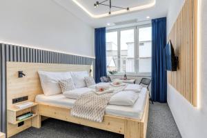 a bedroom with a large bed with blue curtains at Apartmány Prusinovského in Kroměříž