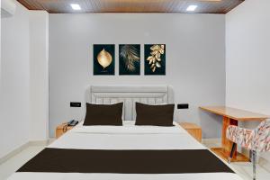 a bedroom with a white bed and a wooden desk at Townhouse Tuessday Suites Nearst Mr Bhatura Bala Sector 122 in Noida